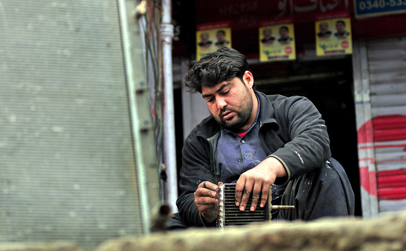 A mechanic busy in repairing work of a car radiator in his workshop at G9 markaz.