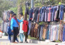 A person selecting jacket from a roadside vendor