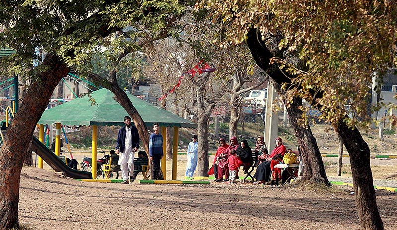 People enjoying sun bath at Kuri Road neighbourhood during a chill weather in the city