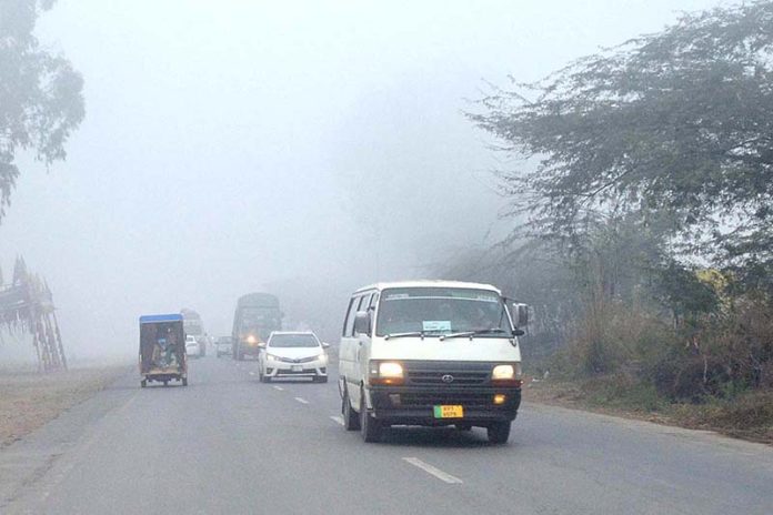 Vehicles on the way at Khushab Road during thick fog that engulfs the city