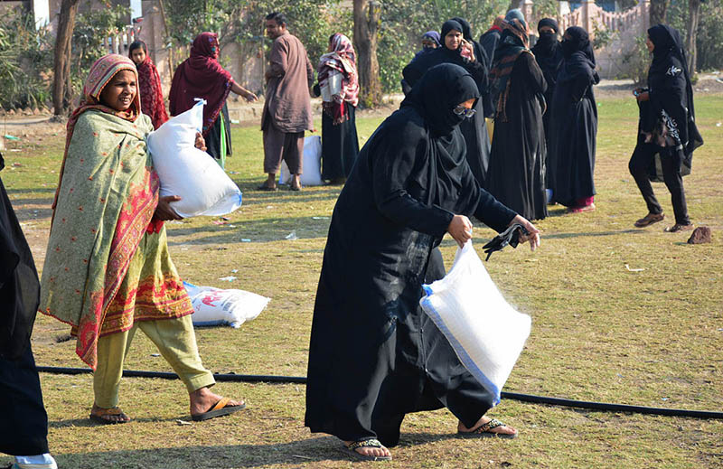Women are carrying subsidized flour bags and taking back to their homes at Latifabad