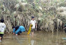 Children are catching fish in the canal at Selawali road on outskirts area of the city