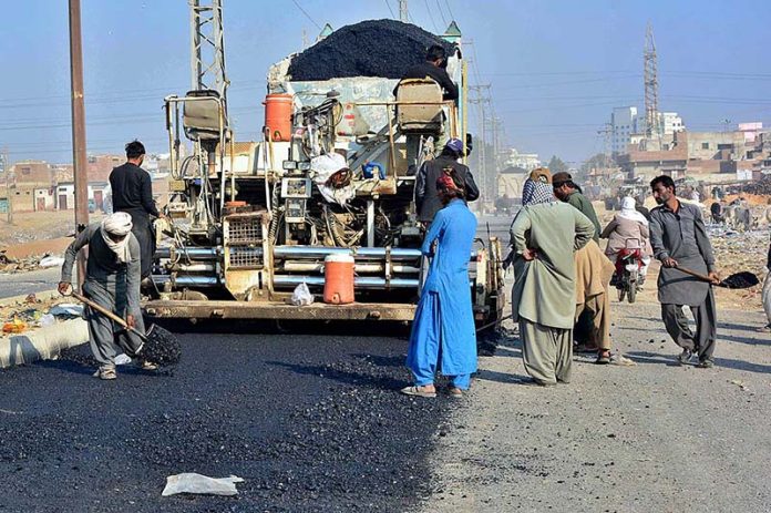 Labourers busy in construction work of Gulistan-e-Sarmast Road during development work in the city