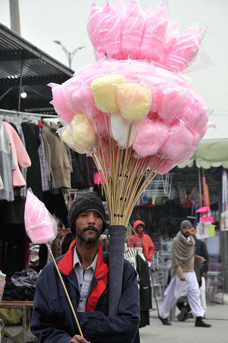 Street vendor selling cotton candy at Weekly Juma Bazar Peshawar Morr