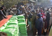 A large number of people standing in queue for purchasing flour bags on subsidized rates