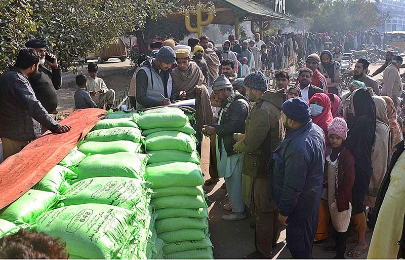 A large number of people standing in queue for purchasing flour bags on subsidized rates