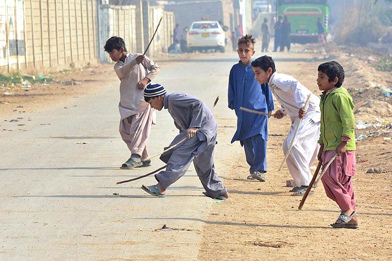 Children playing traditional game on the road at Latifabad