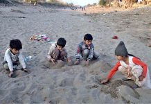 Children are playing with sand on dry canal at Selawali road,according to experts playing with sand is healthy exercise for kids growing