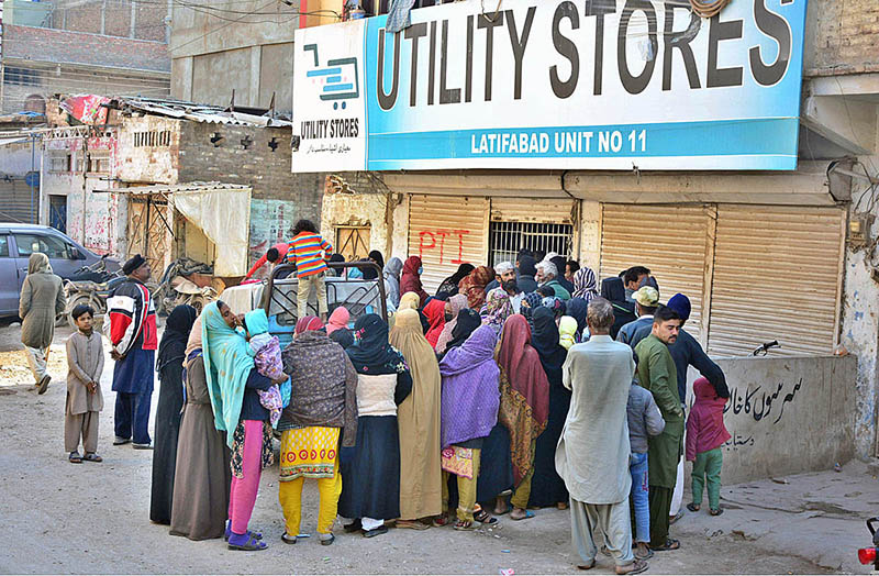 People standing in a queue outside Utility Store to purchase grocery items on subsidized rates at Latifabad