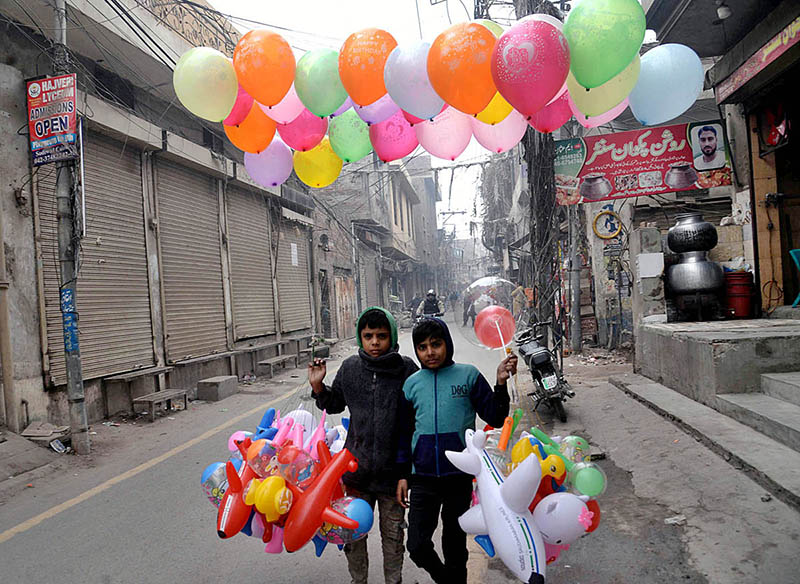 Young street vendors selling colorful balloons