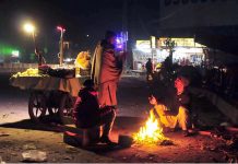 Vendors are getting themselves warm with wood fire at Bhara Kaho
