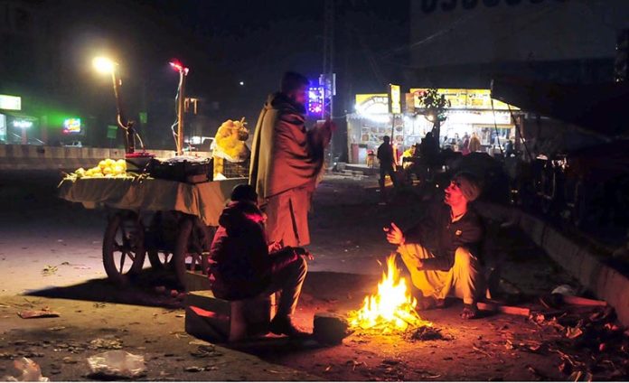 Vendors are getting themselves warm with wood fire at Bhara Kaho
