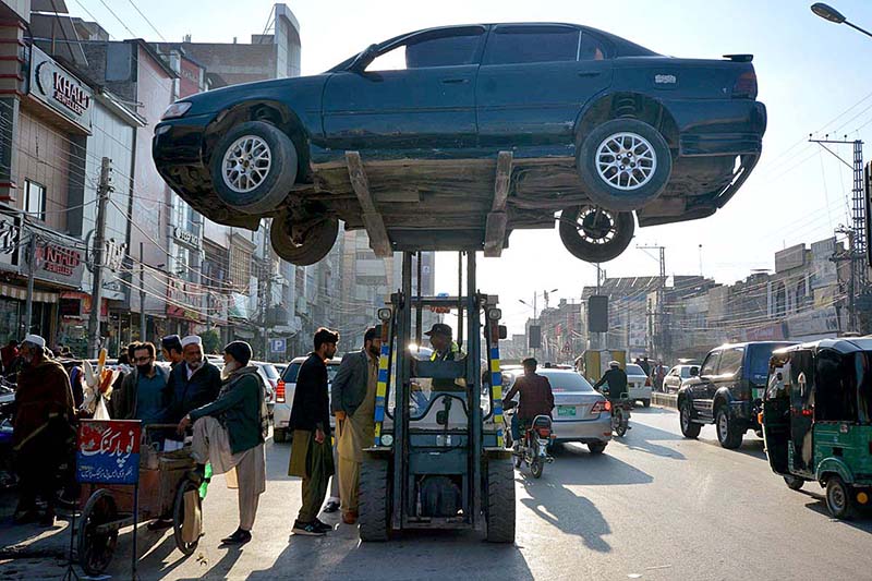 A traffic police warden removing wrongly parked vehicle with the help of fork lifter for smooth traffic flow at Cantt area