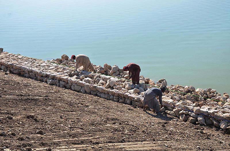 Labourers busy in strengthen embankment after recent flooding and heavy rains at Indus River