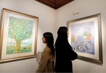 Girls taking keen interest in painting during exhibition by Artist Muhammad Javed at Pakistan National Council of the Arts