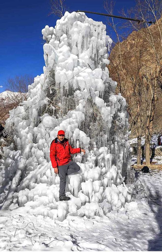 Tourist enjoying at freezed Manthoka Water Fall in the remote area of Gilgit-Baltistan District Kharmang
