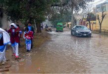 Students are crossing accumulated rain water at Satellite Town