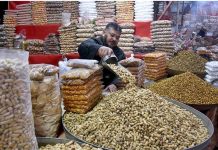 A vendor arranging and selling the variety of dry fruits to attract the customers on his shop in Provincial Capital