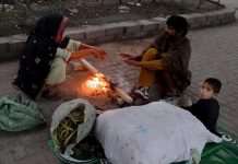 A family gathered around fire to keep themselves warm during cold weather alas the temperature dropped in the city