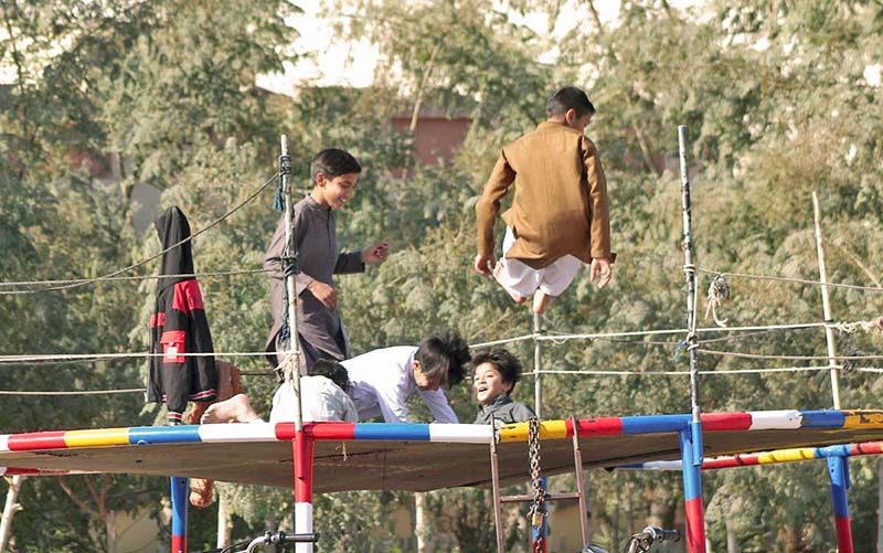 Children jumping on the trampoline at a roadside