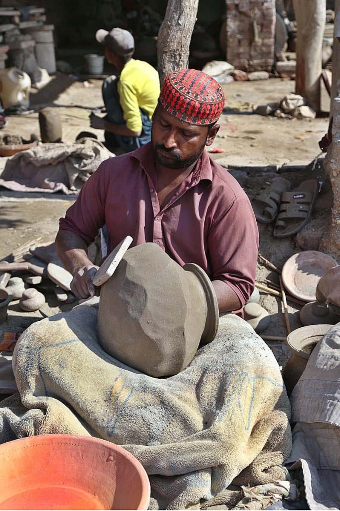 Craftsman busy in preparing clay made pitcher at his workplace at Kumhar Para