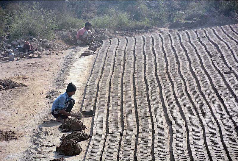 Laborers busy in making clay bricks for contractions at local kiln