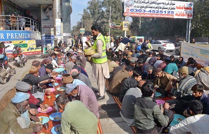People getting free food on Rehmat-ul-Al-Alamin Dastarkhan near Rahman Plaza