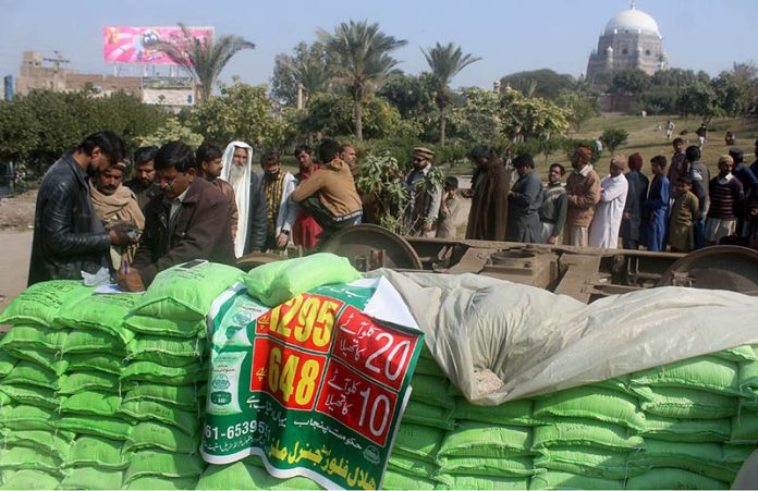 People in a long queue to purchase flour bags at subsidized rates at Ghanta Ghar Chowk in the city