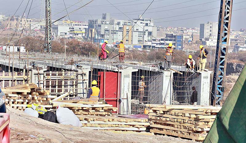 Laborers busy in construction work of a bridge at Islamabad Expressway at Gulberg Green in federal capital territory