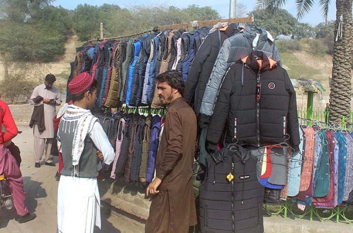 Customer selecting and purchasing jackets from a roadside vendor