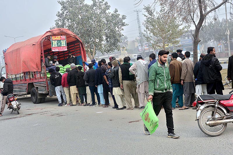 People waiting in queuing to purchase subsidized flour from a delivery truck