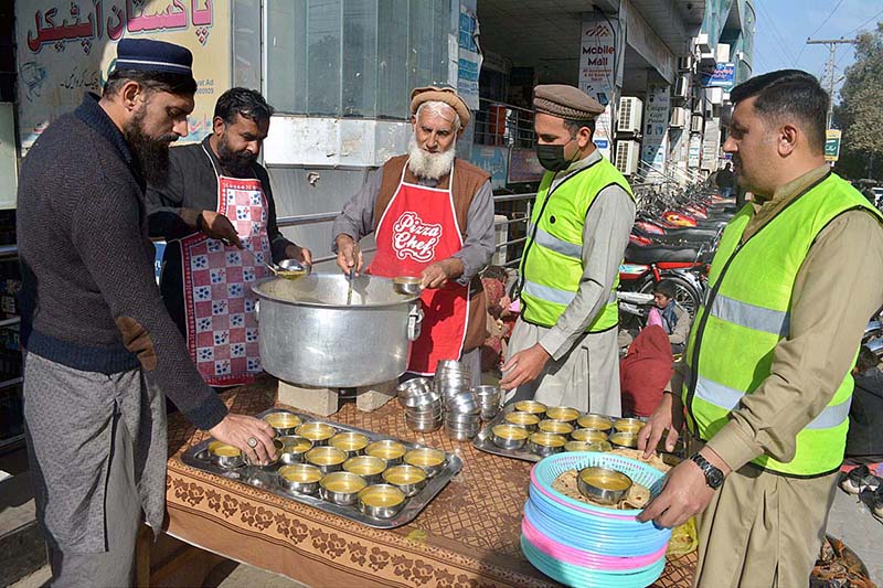 People getting free food on Rehmat-ul-Al-Alamin Dastarkhan near Rahman Plaza