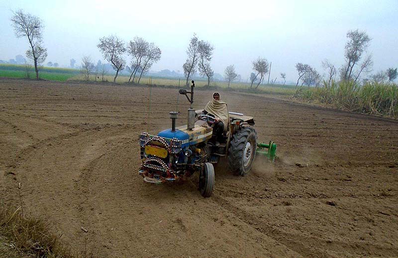 A farmer preparing land for next crop near Lahore road