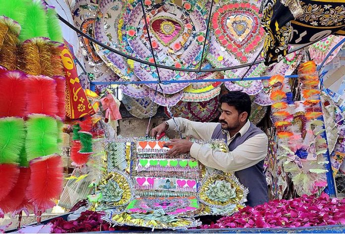 A vendor preparing and displaying the garlands to attract the customers at his shop