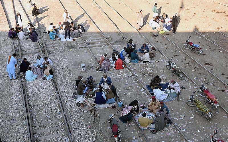People spending their time by playing cards on railway tracks near Railway Station