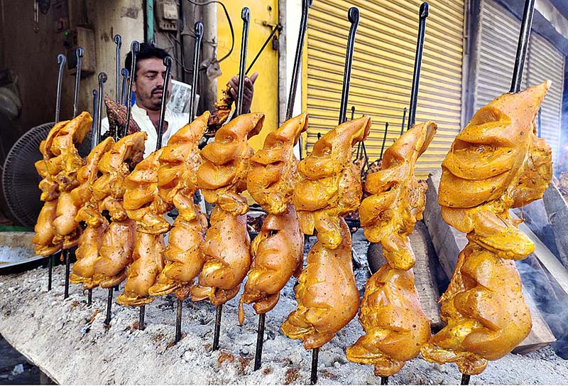 A vendor preparing traditional chicken roast for customers outside his restaurant at Railway Station Road