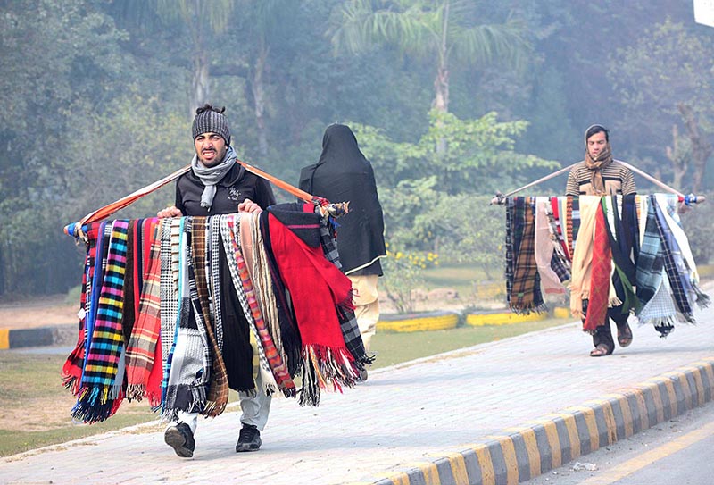 Street vendors carrying woolen scarf for selling while shuffle on the road side in the city