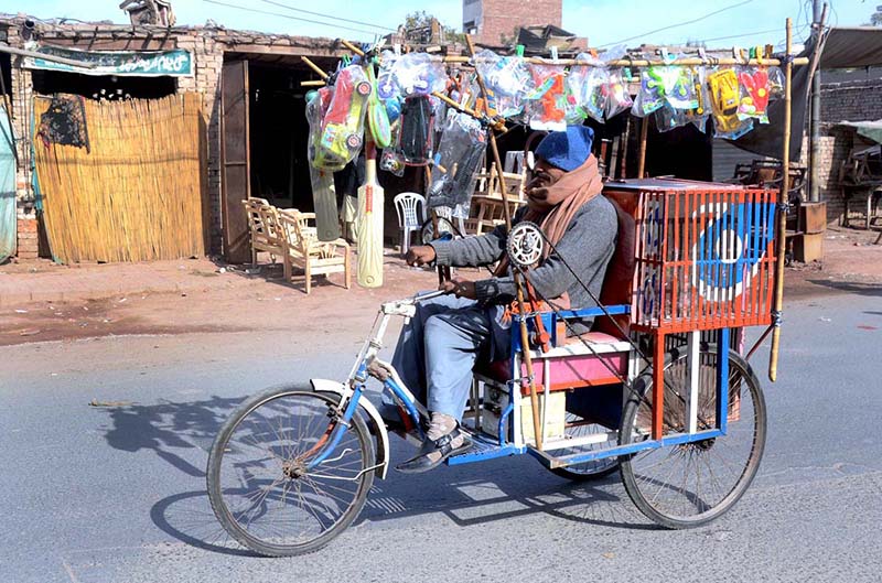 A Disabled person displaying plastic toys on his cycle to attract the customer while shuttling on the road