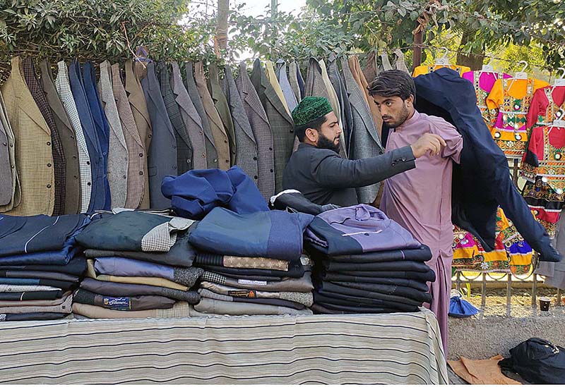 A vendor displaying and arranging coats to attract the customers at Press Club Road