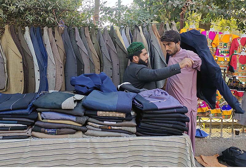 A vendor displaying and arranging coats to attract the customers at Press Club Road