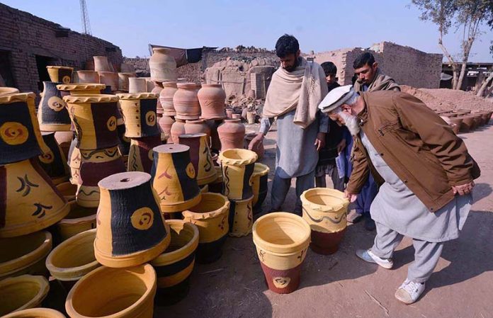 Customer selecting and purchasing colorful plant pots from a vendor at Phandu area