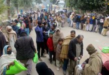 People are standing in a queue to purchase flour bags on subsidized rate