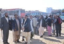 Policemen waiting for moving to their destination, who have come from interior Sindh to perform their duties in the Local Government elections, scheduled to be held on 15th January