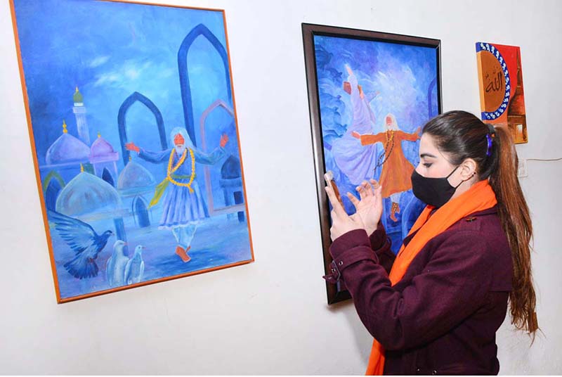 Visitors viewing paintings displayed during second day of the Sindh Sufi Melo at Sindh Museum