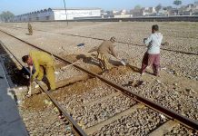 Railway workers busy in repairing a railway track near Jhang road