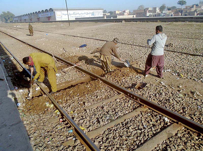 Railway workers busy in repairing a railway track near Jhang road