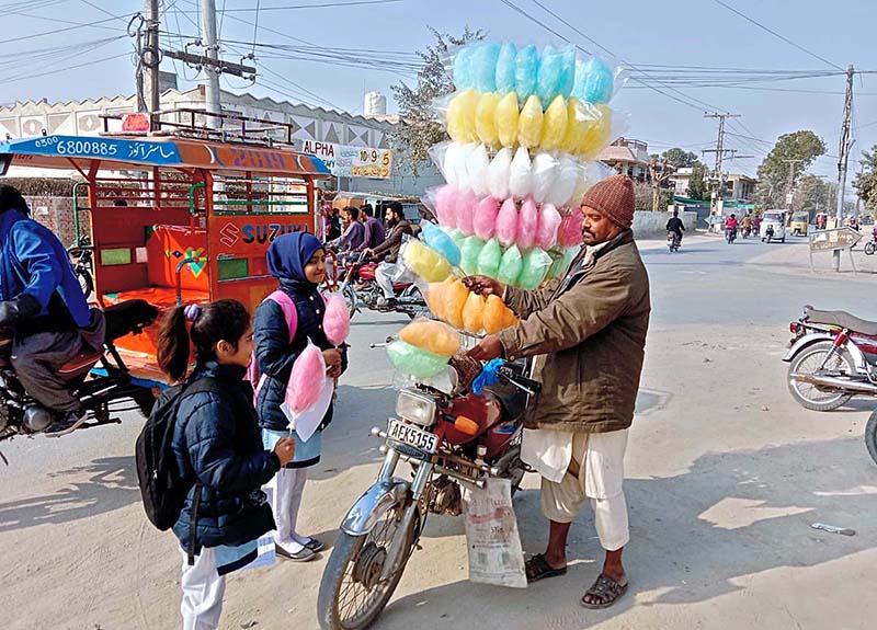A man is selling cotton candies to the school children