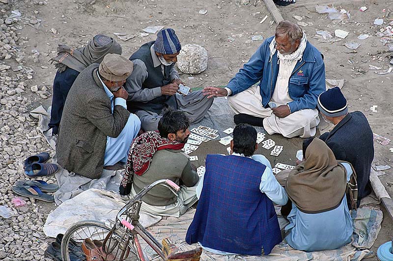 People playing cards to spend their time at railway tracks