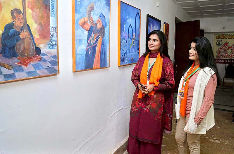 Visitors viewing paintings displayed at the Sindh Sufi Melo in Sindh Museum