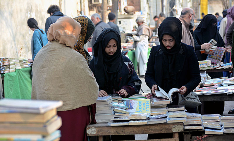 Women selecting old books on a roadside stall at Provincial Capital